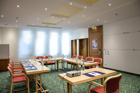 Konferenzraum mit U-Tischform, Projektor und Tageslicht – funktional und einladend gestaltet